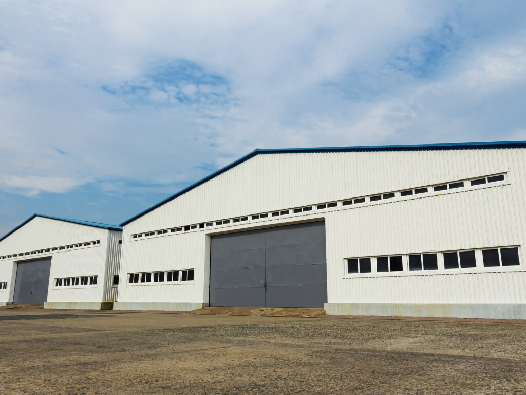 Industrial warehouse featuring two large doors, designed for electric car storage and efficient vehicle access.